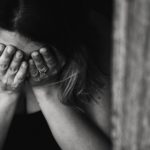 counselling for anxiety that causes woman to hide her face behind her hands after experiencing an anxiety attack