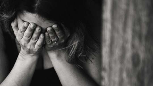 counselling for anxiety that causes woman to hide her face behind her hands after experiencing an anxiety attack