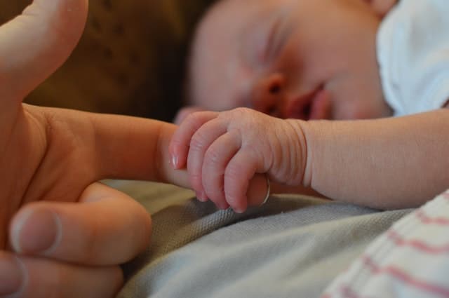 baby-holding-parents-finger-suffering-postnatal-depression